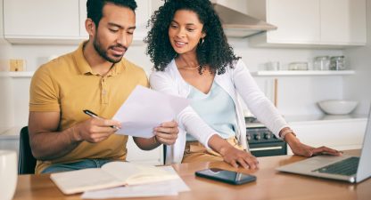 Couple, insurance paperwork and budget planning with laptop
