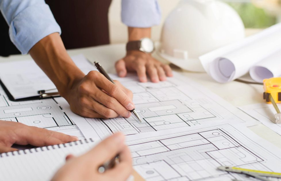 Close-up of an engineer planning a hand-drawn design. with architect equipment Architects talking at the table Teamwork and workflow concepts