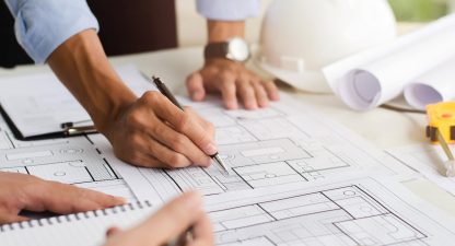 Close-up of an engineer planning a hand-drawn design. with architect equipment Architects talking at the table Teamwork and workflow concepts