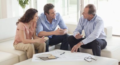 Couple sitting on sofa talking to remodeling contractor